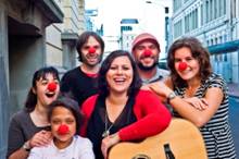 Anika Moa, who has re-released the Cure Kids song You Make the Whole World Smile, surrounded by Cure Kids ambassadors and two of her band members